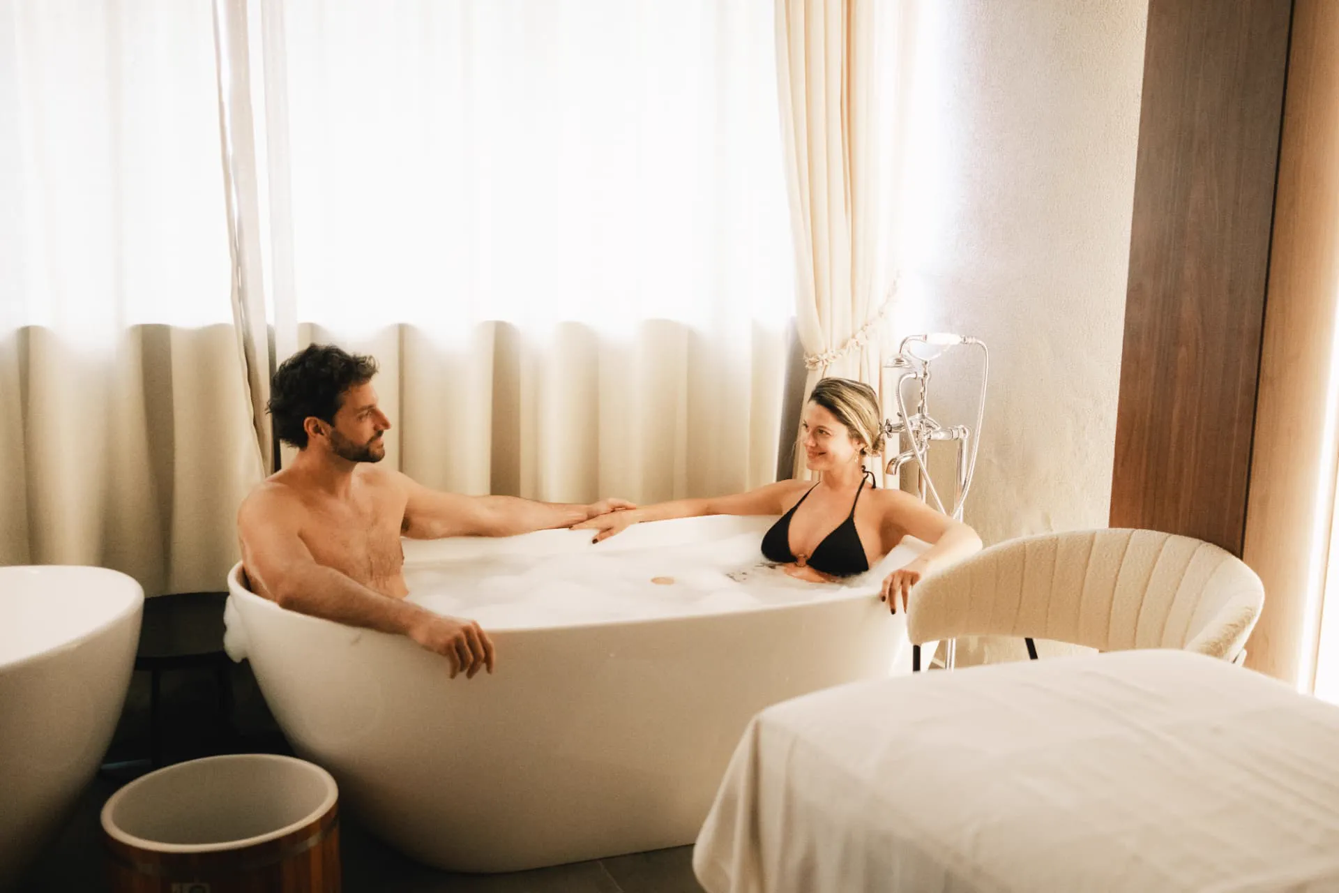Casal relaxando em banheira de hidromassagem no Chris Wellness Spa